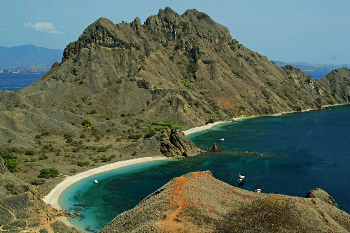 Komodo Island coastline with traditional wooden boat, Komodo National Park